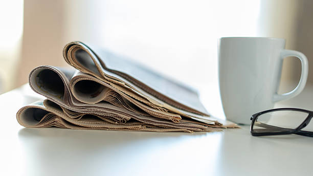 istock newspaper and eyeglasses at office desk 2245159896