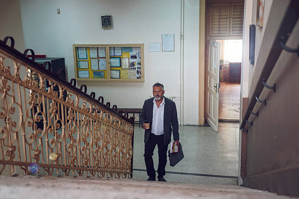 istock Middle-aged professor on university stairs 2245162386