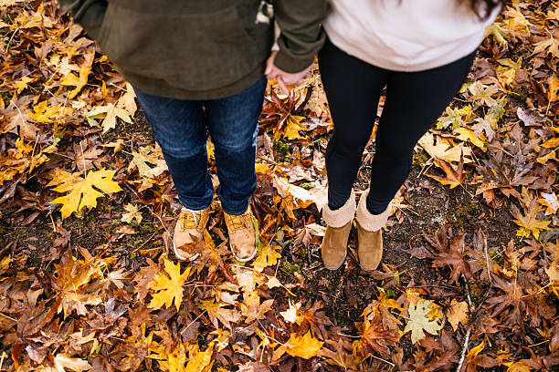A Caucasian man and Hispanic woman exploring fall in Washington state, taking in the beauty of the colorful big leaf maple leaves.