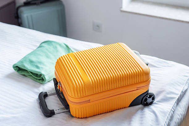 istock Travel suitcase on hotel bed preparing for journey 2245163243