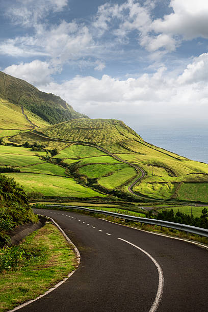 istock Scenic Road Through Rolling Green Hills by Ocean 2245163919
