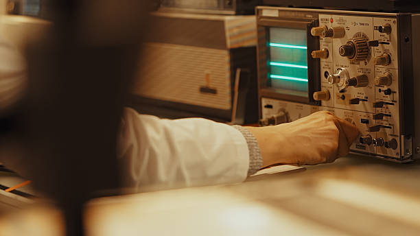 Retro medical research laboratory. Oscilloscope and other old technology being used to conduct research. Team of scientists working to collect data