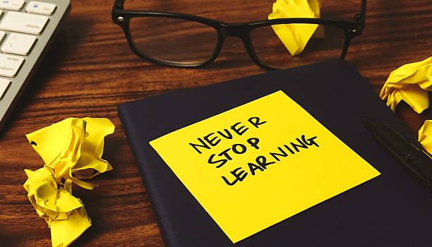 istock Lifelong Learning Motivation: 'Never Stop Learning' Reminder on Desk with Crumpled Paper 2245168118