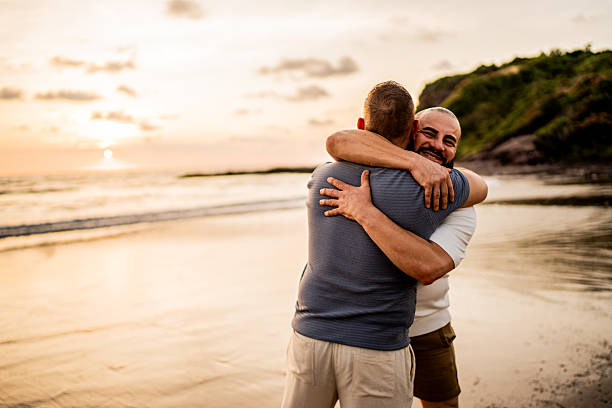 istock Gay couple embraced on the beach 2245177717