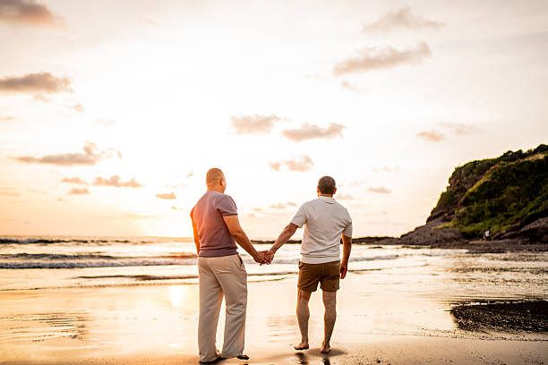istock Gay couple walking holding hands on the beach 2245177751