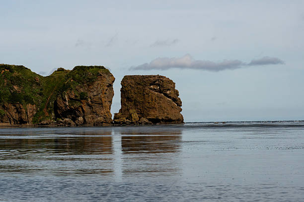 istock Towering coastal cliffs divided by erosion above ocean 2245178144