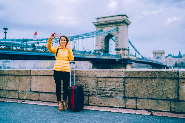 istock Solo traveller having a video call near the Chain Bridge in Budapest 2245180021
