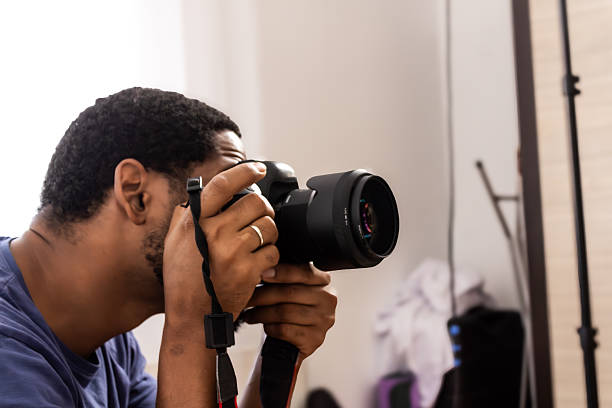istock Man photographer holding camera lens focusing on subject 2245180380