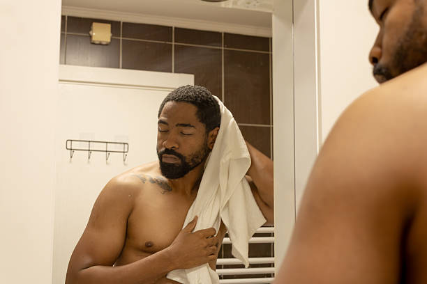 istock Man drying hair with towel in bathroom mirror 2245180661