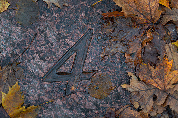 The metal number 4 on a green façade.