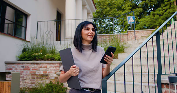 istock Pretty girl university student user holding cell phone and laptop using education tech apps looking at smartphone texting messages standing outside 2245183067