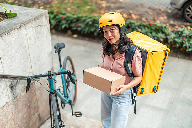 istock Asian female courier delivering package on bicycle 2245188036