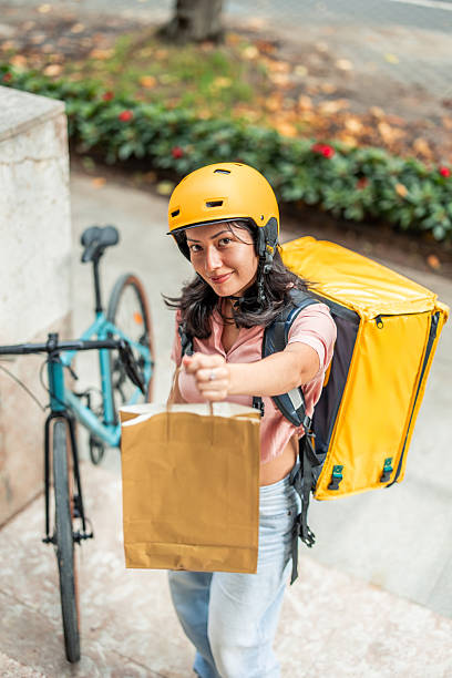 istock vertical Asian delivery woman delivering food package by bicycle 2245188043