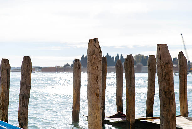 istock Wooden piers on shimmering waterfront with distant shoreline in bright daylight 2245188124