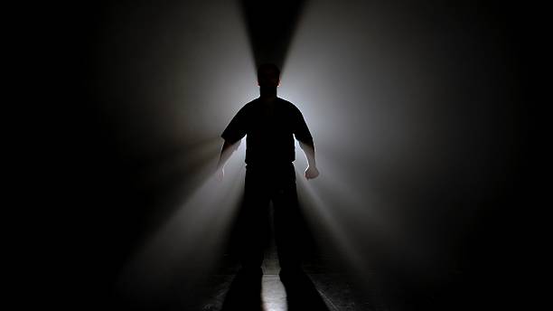 istock A Shadowed Figure a Martial Artist Illuminated by Bright Light 2245190496