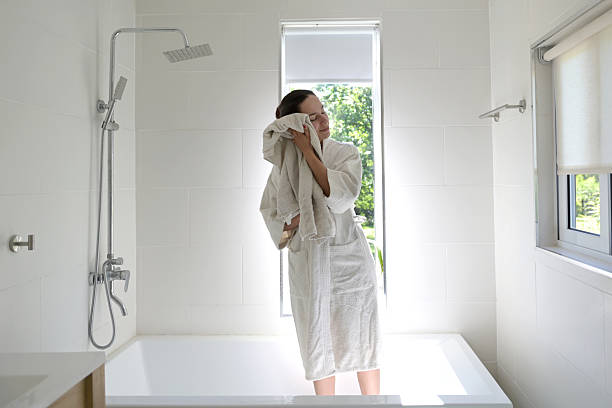 istock woman drying herself after bathing 2245190596