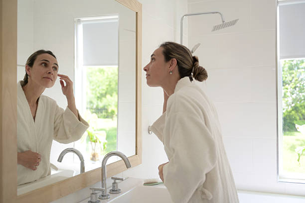 istock woman combing her hair in the bathroom 2245190614