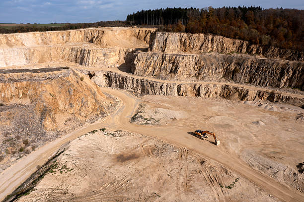 Aerial view of an open pit mining site of limestone materials for construction industry on a sunny day.