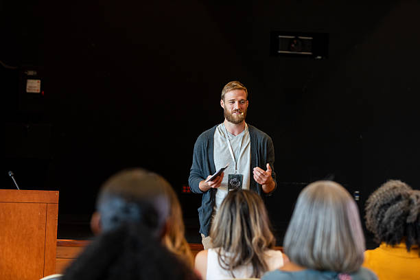 istock Man speaking at podium to an audience, gesture with hands. 2245192471