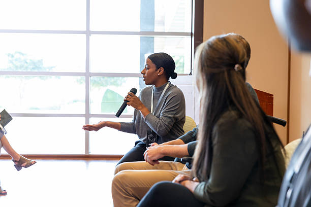 istock Confident speaker engages audience in discussion at indoor event 2245192482