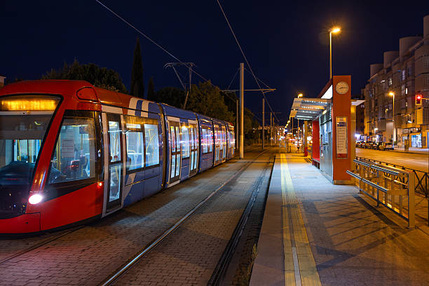 istock Modern tram waiting at urban station at night 2245196546
