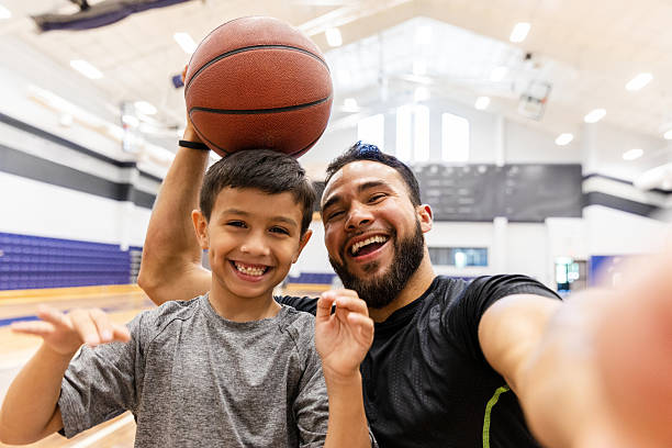istock Father and son share a joyful moment while playing basketball in the gym. 2245196645
