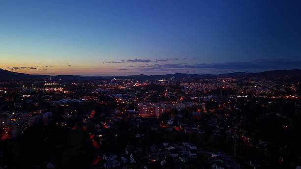 istock Evening city panorama with radiant lights and flowing river 2245197994