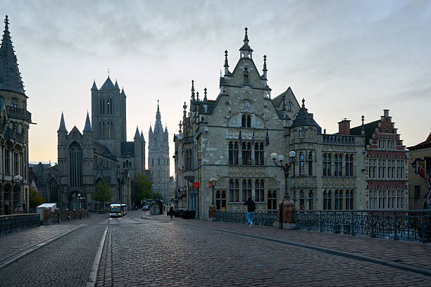 The view on Saint Michael’s Bridge to Nicholas church as traffic starts at dawn. Ghent, Belgium. September 23, 2024.