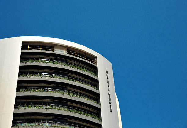 Windhoek, Namibia: the Mutual Tower, is a skyscraper located on Independence Avenue in the Central Business District. Completed in 2010, it stands 100 meters tall with 21 floors, making it the tallest building in the country. Designed by Barnard Mutua Architects, with project architects Francis Mutua and Herrmann Mueller, it serves as the headquarters for Old Mutual Investment Group Namibia. As the nation's first green high-rise, it incorporates energy-efficient lighting, motion sensors, a gym, and cyclist amenities like parking and showers.