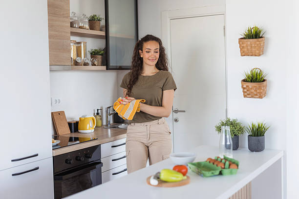 istock Woman drying hands with towel in modern kitchen 2245204478