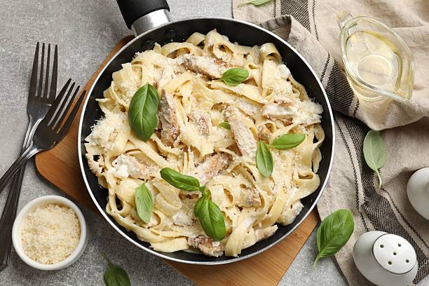 istock Delicious pasta Alfredo with chicken served on grey table, flat lay 2245205991