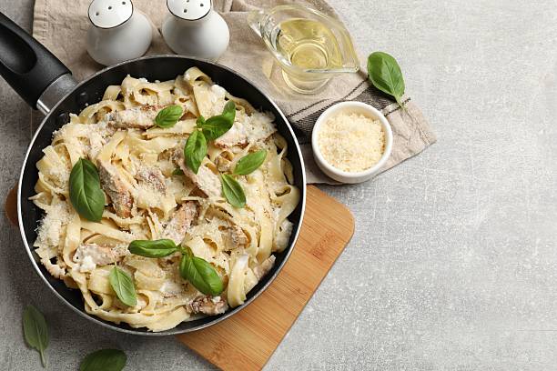 istock Delicious pasta Alfredo with chicken served on grey table, flat lay. Space for text 2245206012
