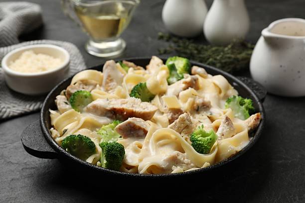 istock Delicious pasta Alfredo with chicken served on black table, closeup 2245206025