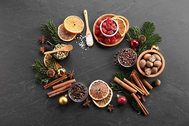 istock Frame of different aromatic spices and fir tree branches on black table, flat lay. Christmas season 2245206275