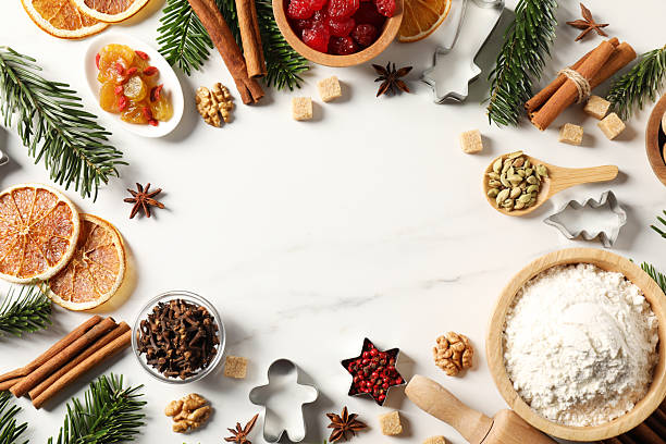 istock Frame of different aromatic spices and fir tree branches on white table, flat lay with space for text. Christmas season 2245206345