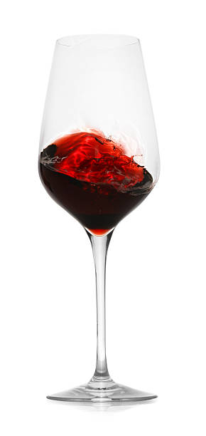 istock Red wine splashing in glass on white background 2245207838