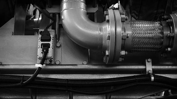 istock piston gas engine electric generator with many valves and pipes. The engine is orange and has many valves. 2245208019
