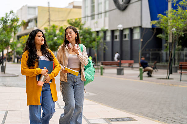 istock College students walking on campus reviewing notes 2245208386
