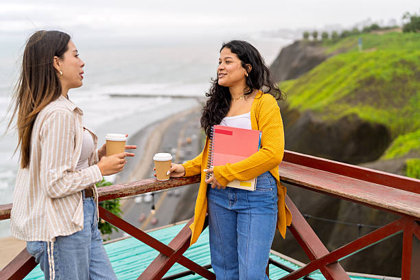 istock College students talking, holding coffee cups, enjoying break 2245208507