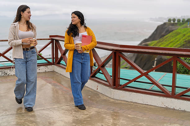 istock College students discussing walking by coastal railing 2245208518