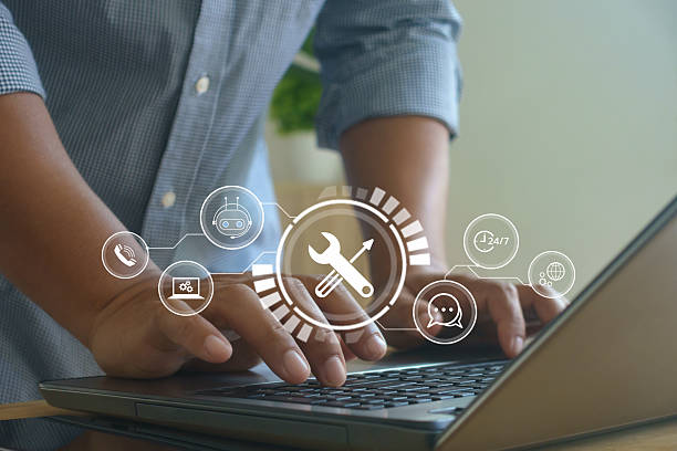 Man typing on laptop with digital interface icons showing tools, chatbot and 24/7 service, symbolizing online technical support, IT maintenance and customer service technology in business.