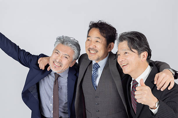 Portrait of senior professionals with arms crossed posing side by side together on white background