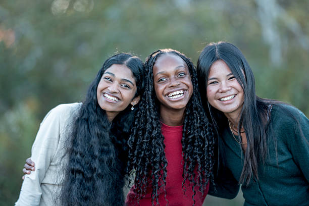 istock Three Friends Smiling Outdoors: Diverse Women Enjoying Time Together 2245213227