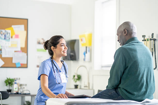 istock Caring Hispanic Nurse In Blue Scrubs Interacts With African American Elder Patient During Clinic Visit 2245213478