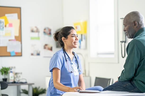 istock Caring Nurse In Scrubs Talks With Elderly Patient In Bright Clinic Setting 2245213483