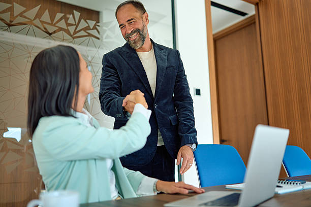 istock Business colleagues shaking hands making agreement in office 2245215523