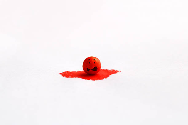 Sphere falls in fright into a drop of red ink
