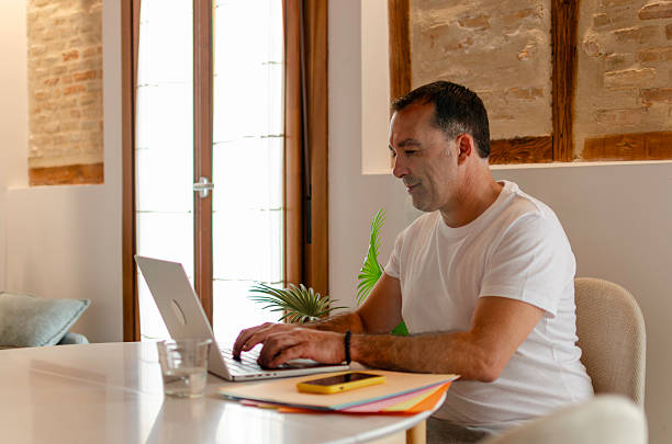 istock Man working on laptop at home remote office 2245217950