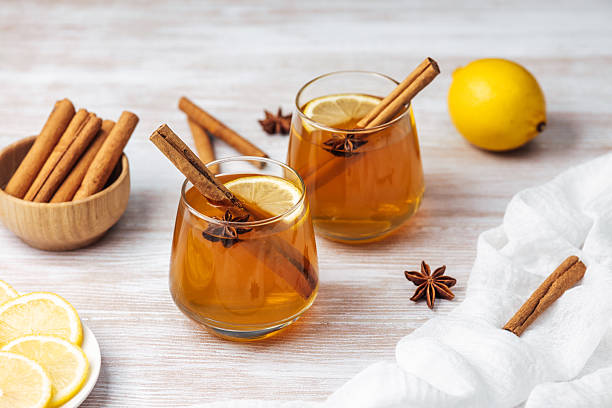 istock Warm drinks with cinnamon sticks, lemon slices and star anise on a wooden table 2245219947