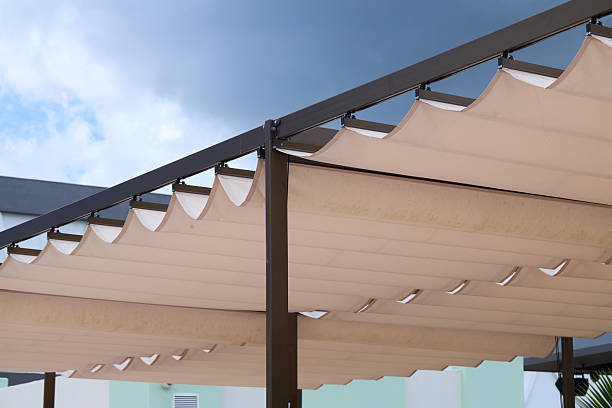 istock Modern resort pergola with fabric awning, blue sky, outdoor shade structure, architectural summer design 2245222238